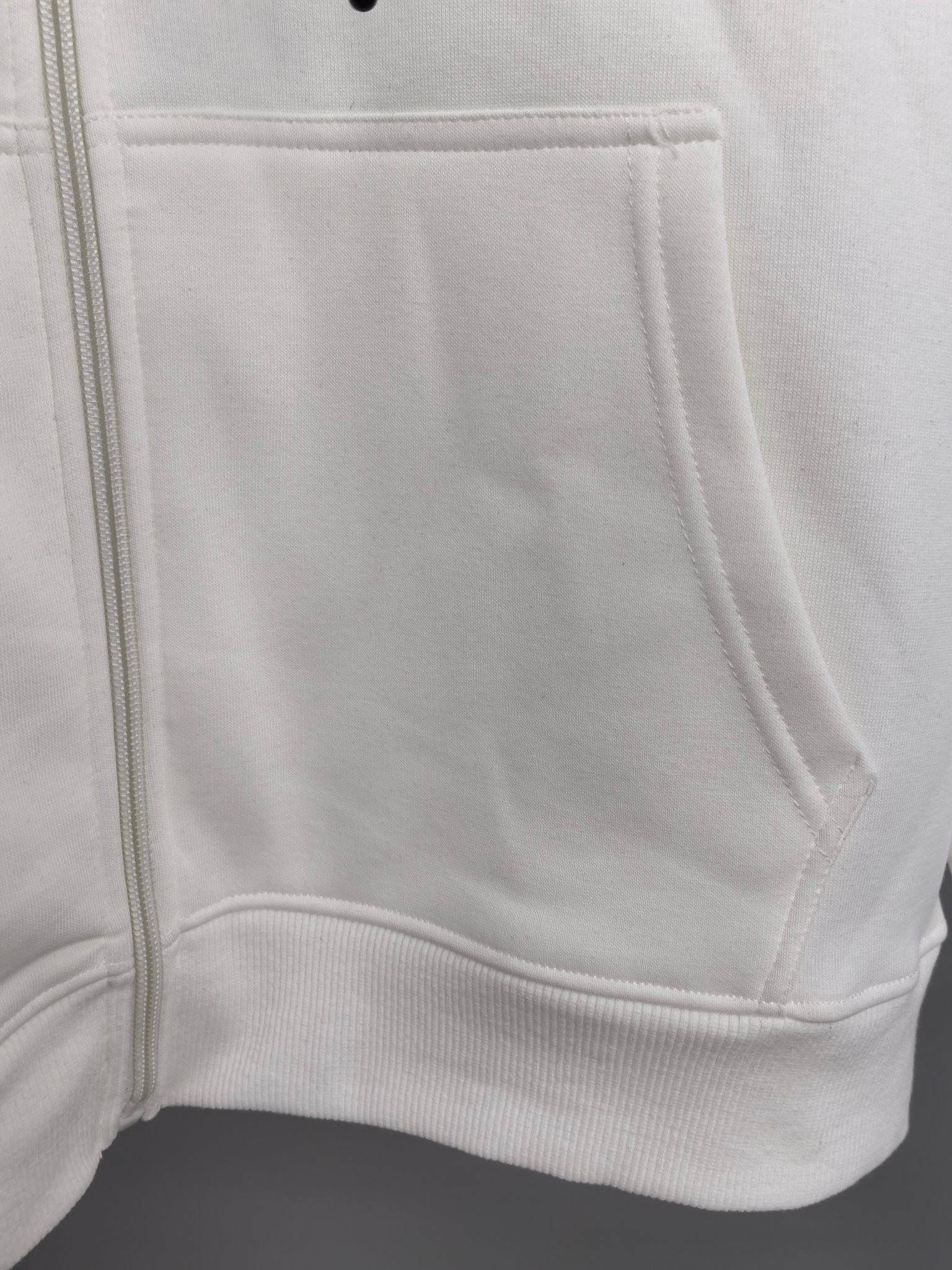 White zip-up hoodie front pocket and zipper tape detail