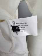 White hoodie fabric label showing “BODY: 100% COTTON” and care text