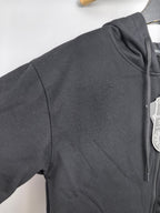 Black zip-up hoodie with ribbed hood and sleeve seam detail