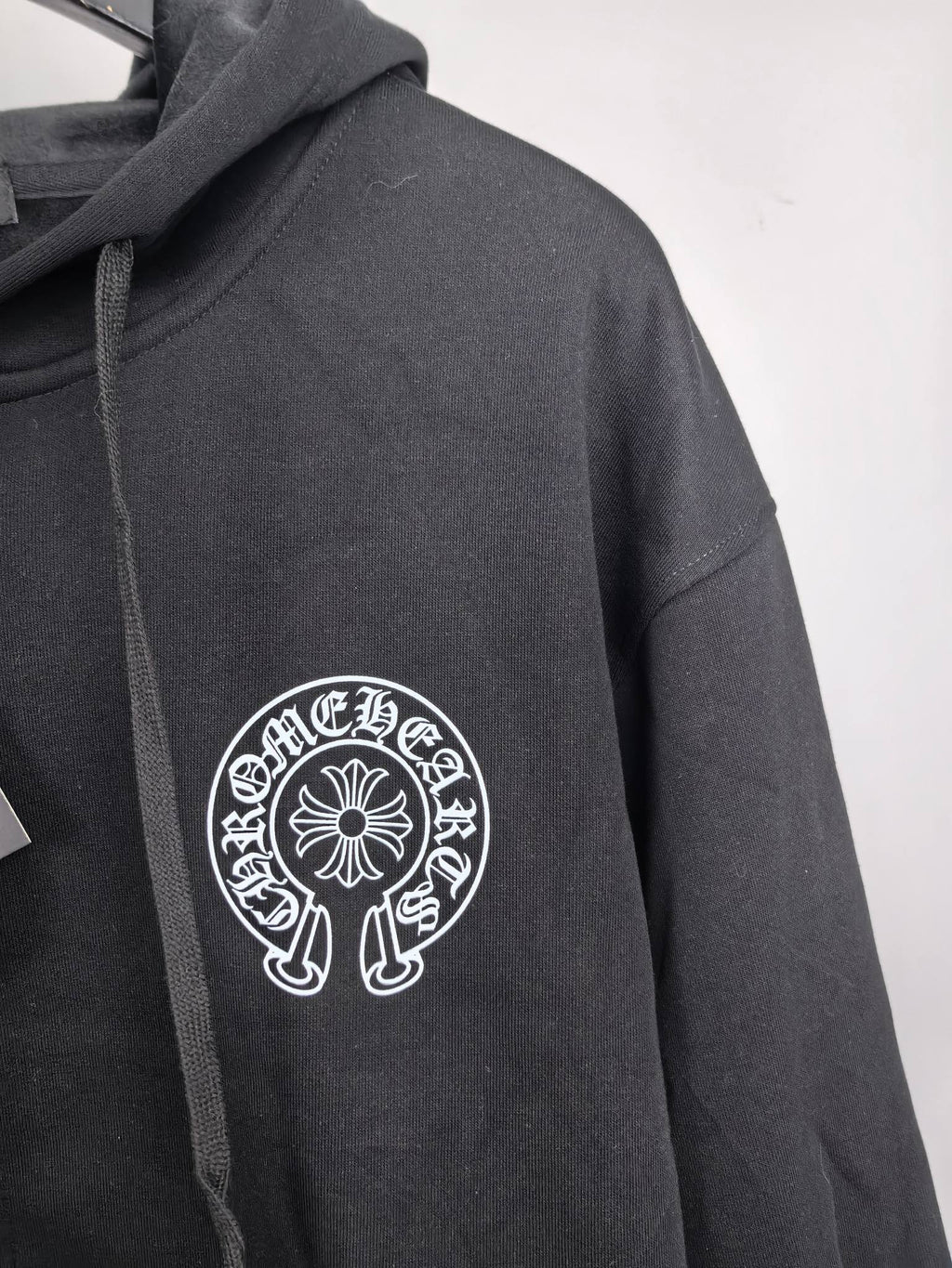Black zip-up hoodie sleeve with circular chest logo embroidery