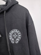 Black zip-up hoodie sleeve with circular chest logo embroidery