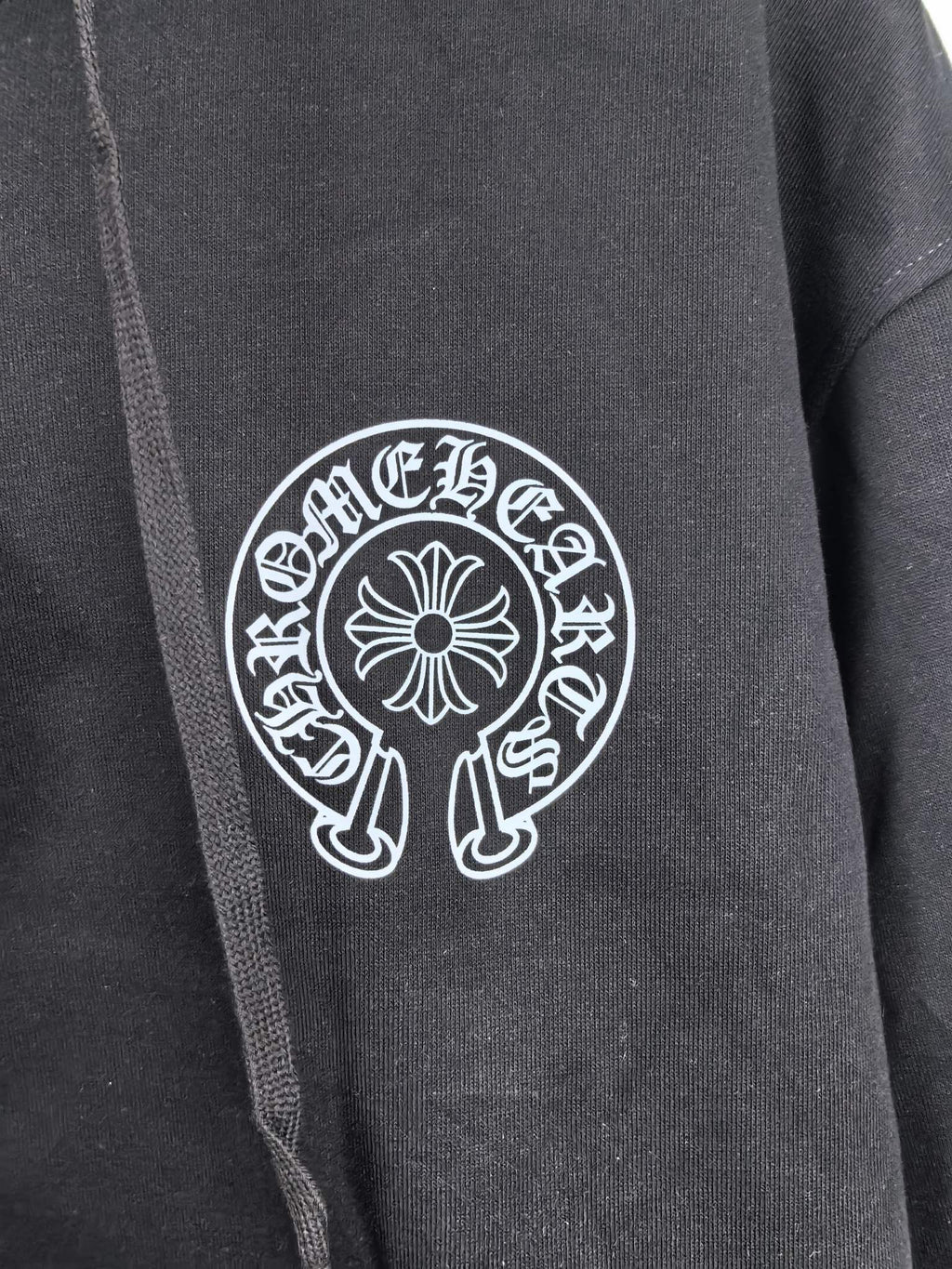 Black zip-up hoodie front with large circular logo patch