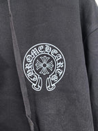Black zip-up hoodie front with large circular logo patch