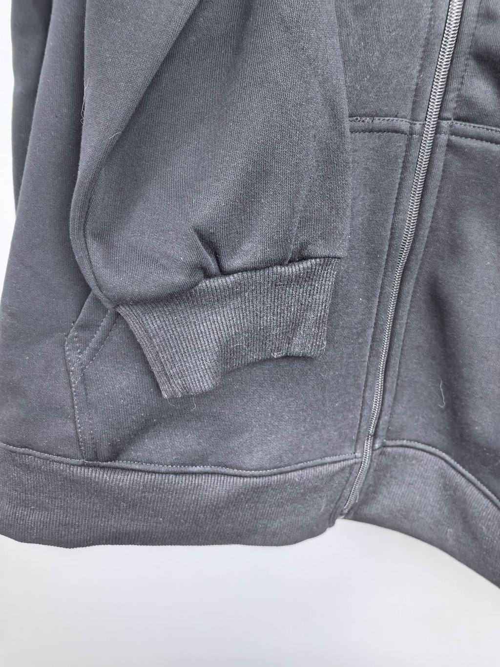 Black zip-up hoodie with front kangaroo pocket and stitched hood