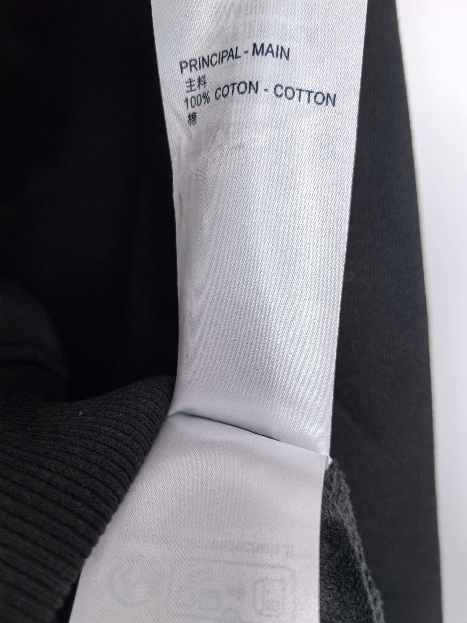 Black hoodie label reading '100% COTTON' and 'PRINCIPAL - MAIN'.
