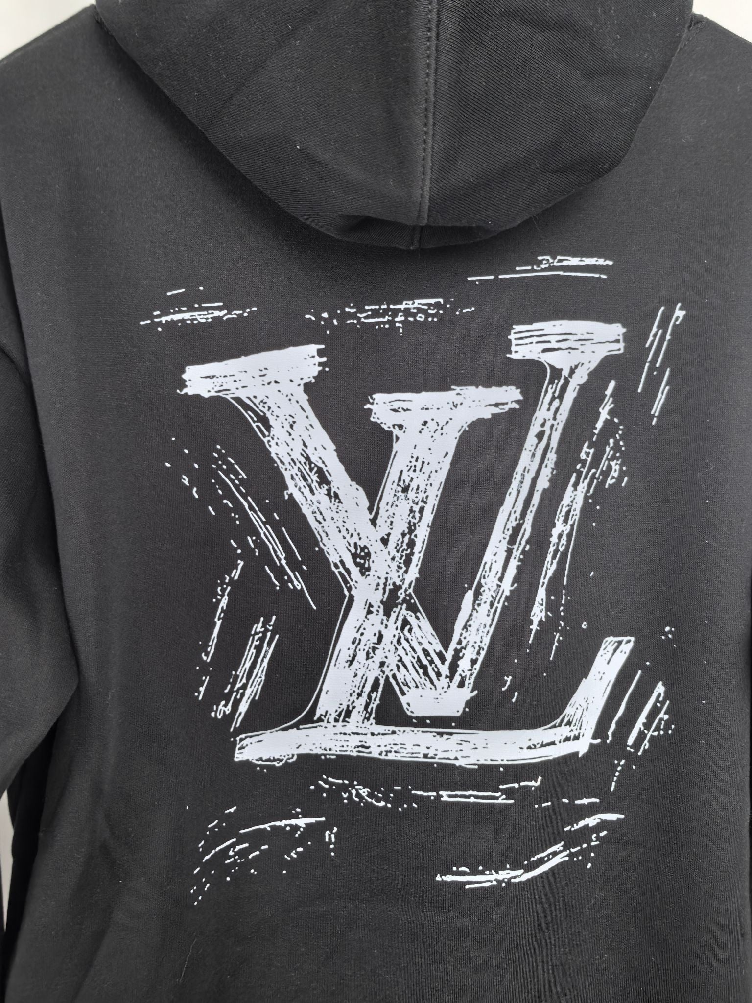 Black hoodie hood with large Louis Vuitton LV graphic print on the back.