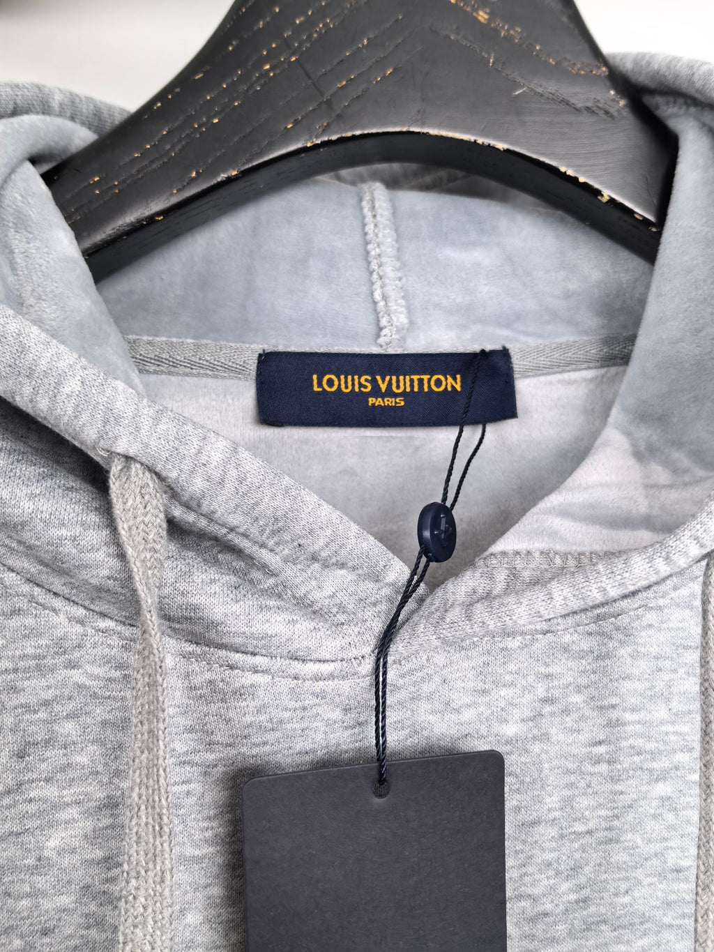 Heather gray hoodie hood with Louis Vuitton Paris tag at the neckline