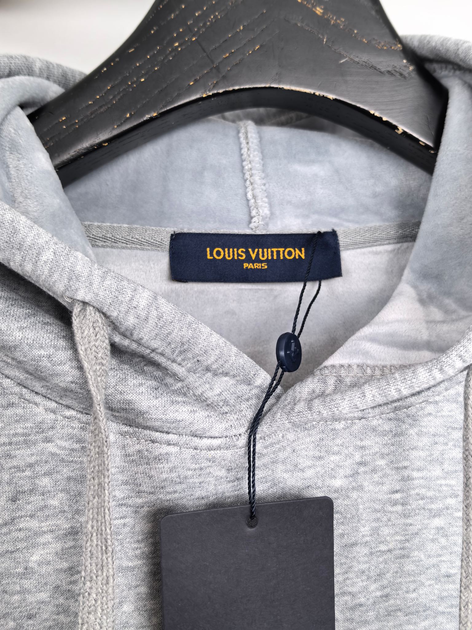Heather gray hoodie hood with Louis Vuitton Paris tag at the neckline