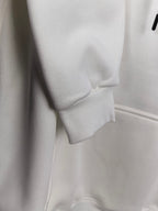 White hoodie hem and ribbed cuff detail, front pocket panel visible.