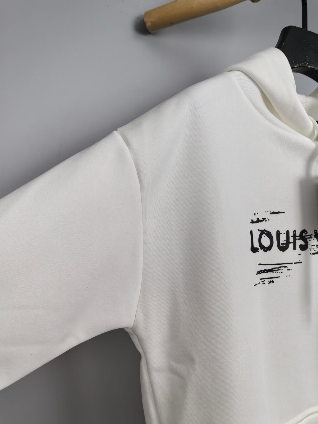 Louis Vuitton hoodie sleeve, white, small LV logo near upper arm.