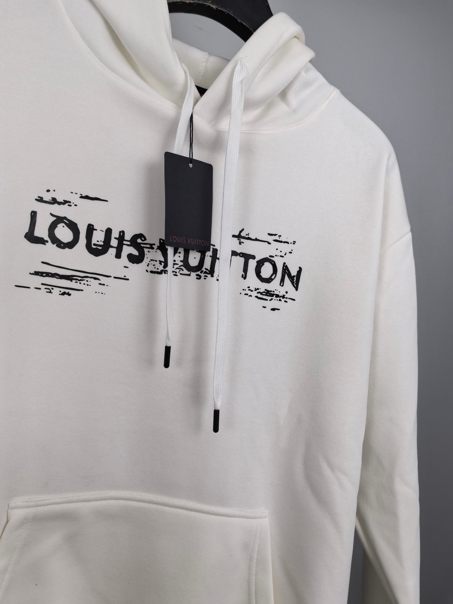 Louis Vuitton long-sleeve hoodie, white, centered LV logo and black drawstrings.