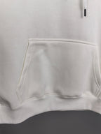 White hoodie front pocket and waistband hem detail.