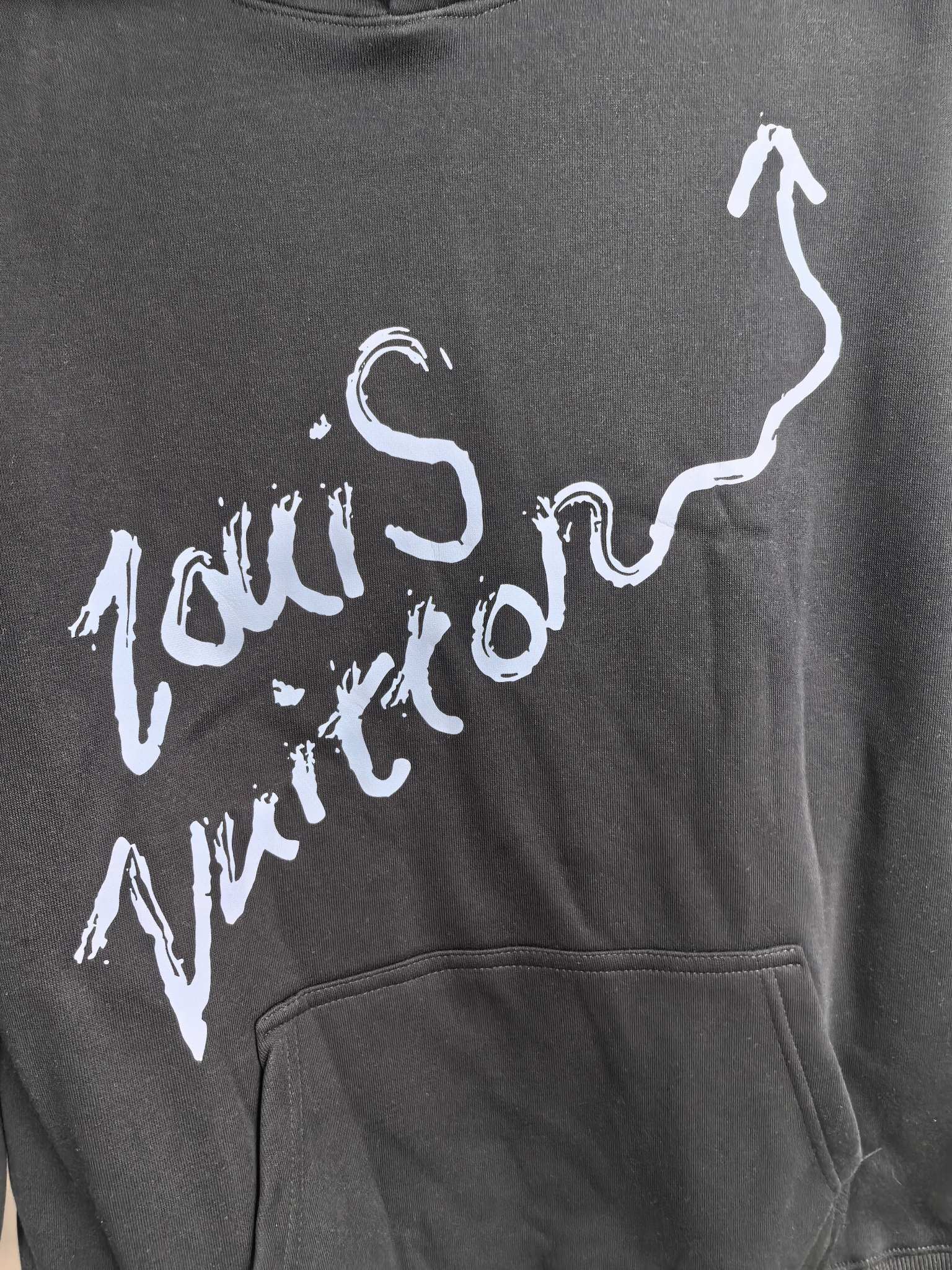 Dark gray hoodie chest graphic logo in white paint-style lettering