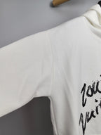 White hoodie sleeve with partial black graffiti graphic print