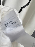 White hoodie fabric care tag inside collar with 100% content and washing marks