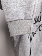 Gray ribbed-cuff hoodie sleeve with black script print detail