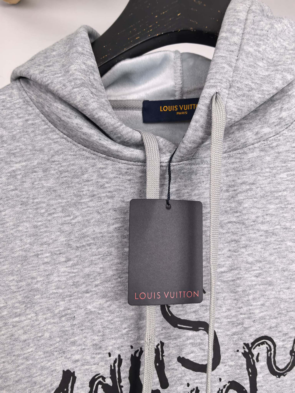 Gray pullover hoodie neckline with black script print and inner brand label
