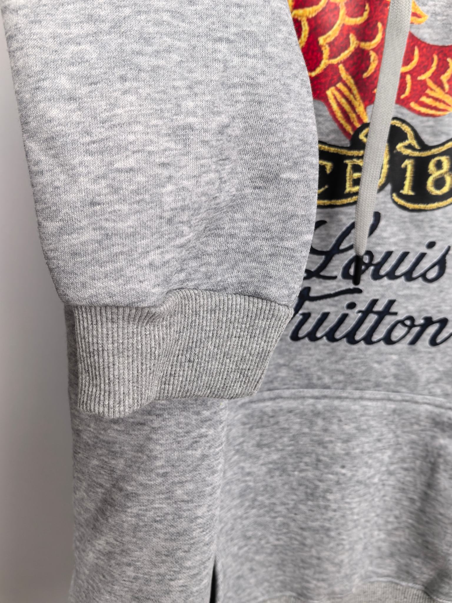 Gray hoodie sleeve and cuff with drawstring pocket area and Louis Vuitton print