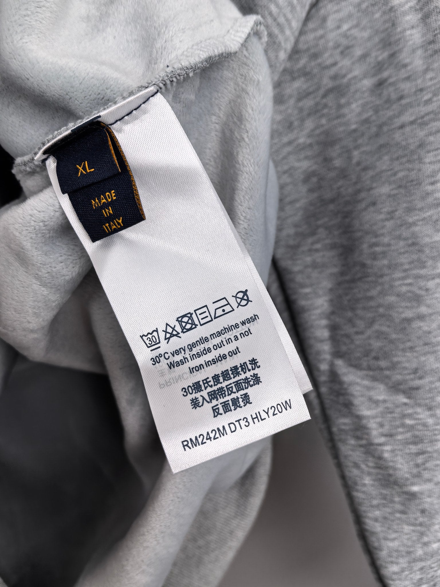 Gray hoodie interior tag marked “XL” and made in Italy