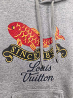 Gray hoodie front graphic featuring red fish, gold details, and Louis Vuitton script