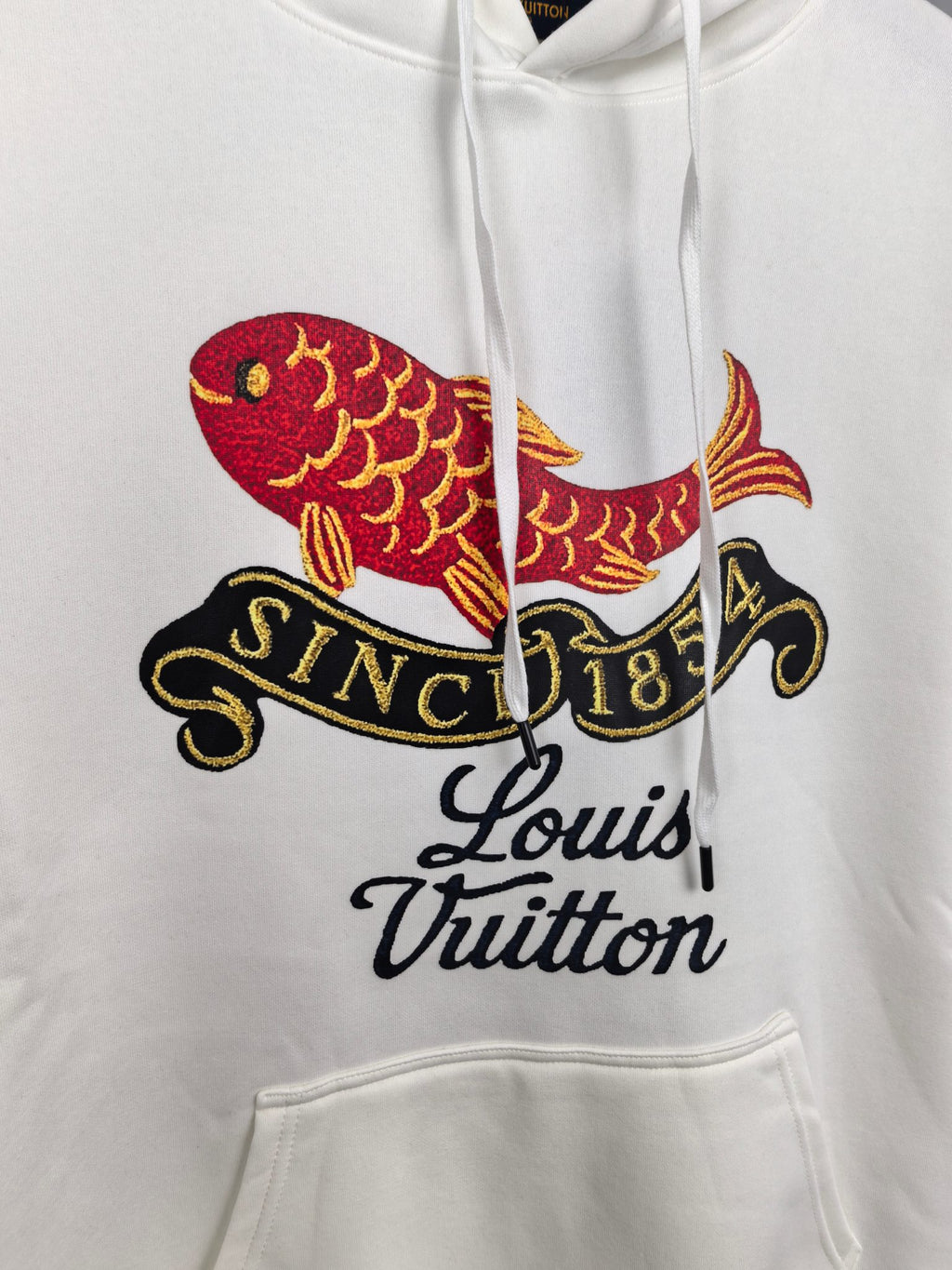 White hoodie chest print featuring colorful fish and Louis Vuitton script