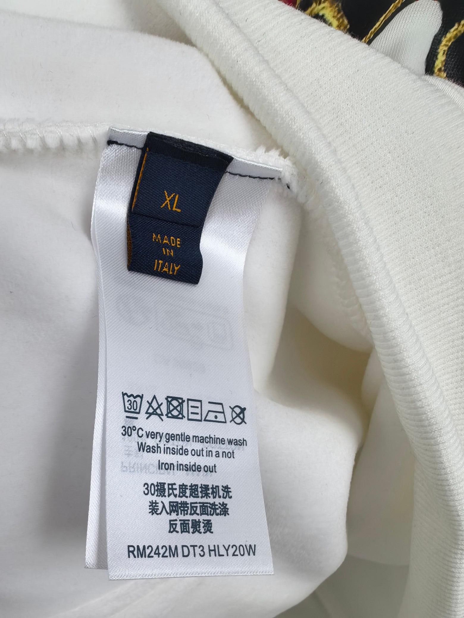 Hoodie size label XL and care instructions on white fabric