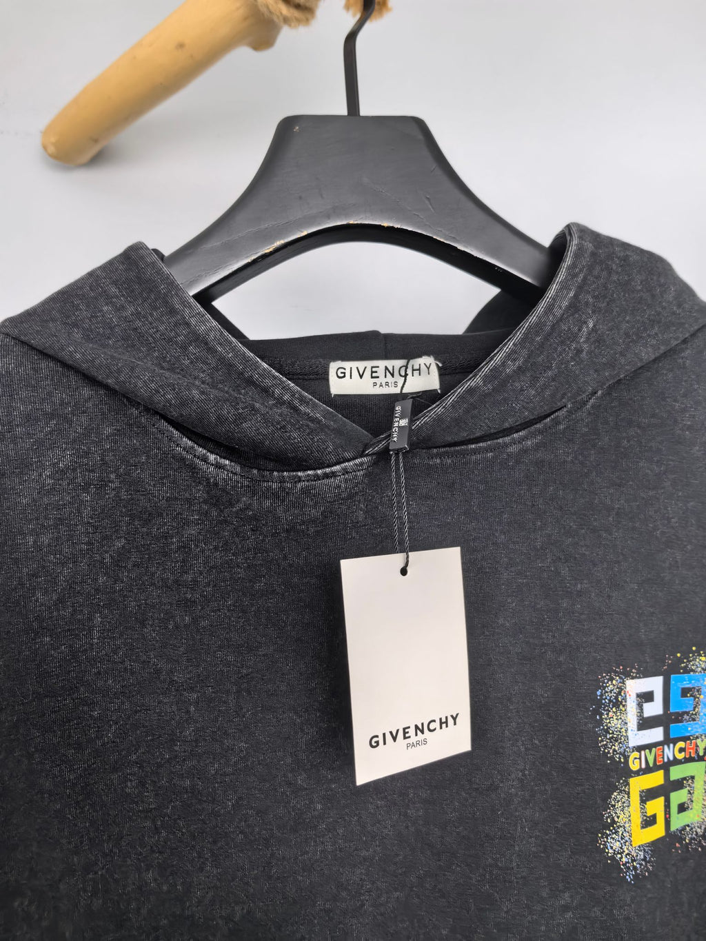Charcoal hoodie collar with neck label and hanging garment tag