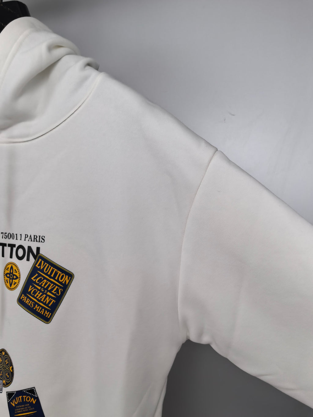 White Louis Vuitton hoodie sleeve with logo patch detail near cuff