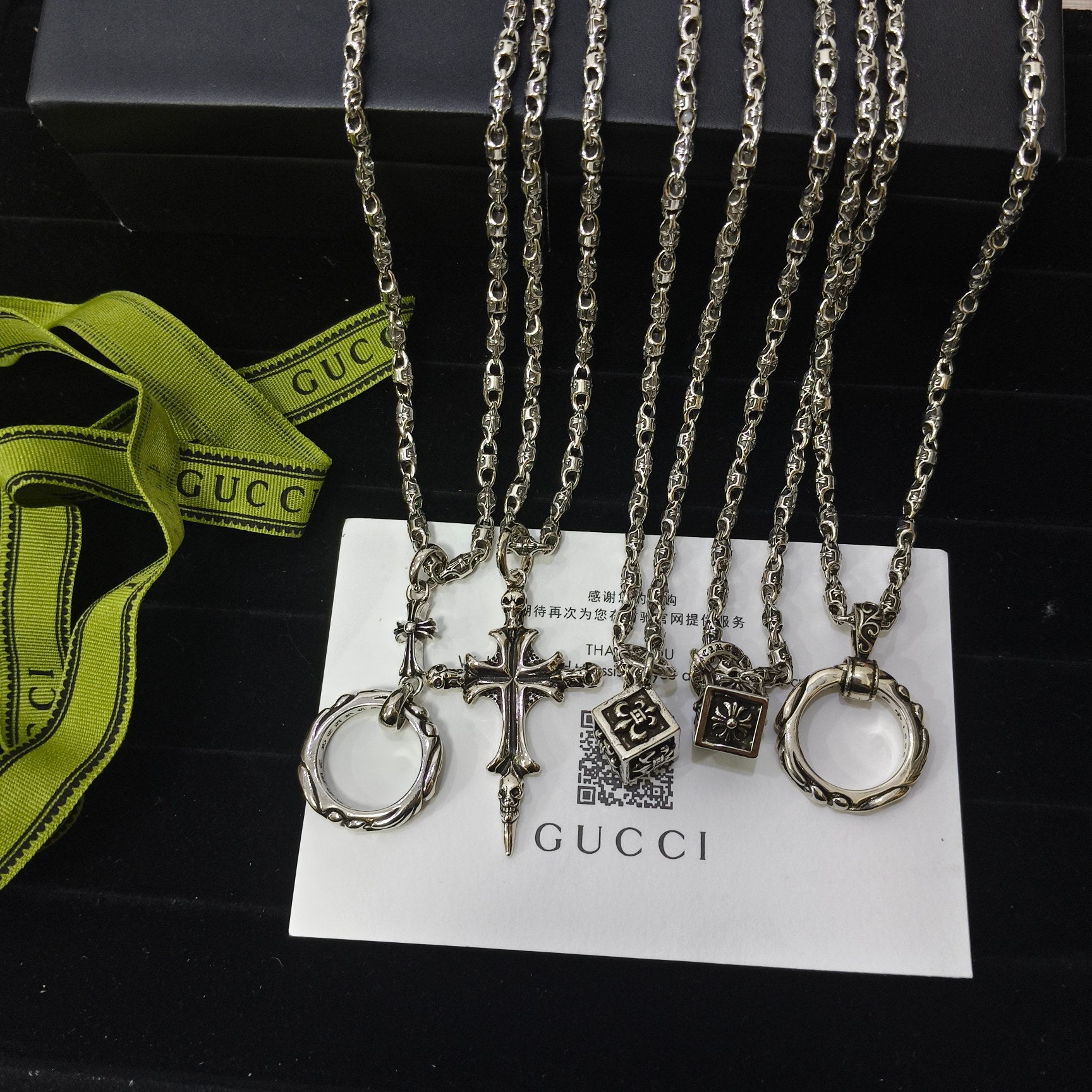 Silver-tone charm necklace set with ring, cross, and tag charms on chain links