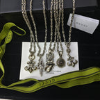Silver-tone charm necklace set with ornate cross and medallion charms on chains