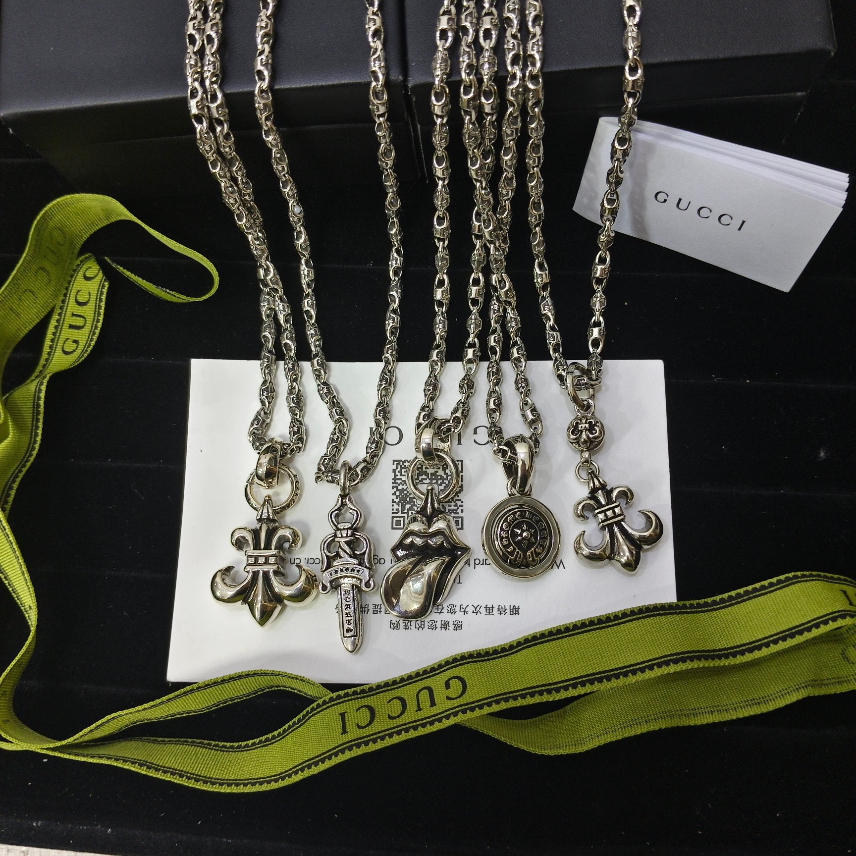 Silver-tone charm necklace set with ornate cross and medallion charms on chains