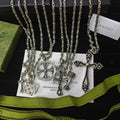 Silver-tone charm necklace set with cross, key, and lock pendants on chains