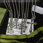 Silver-tone charm necklace set with cross, key, and lock pendants on chains