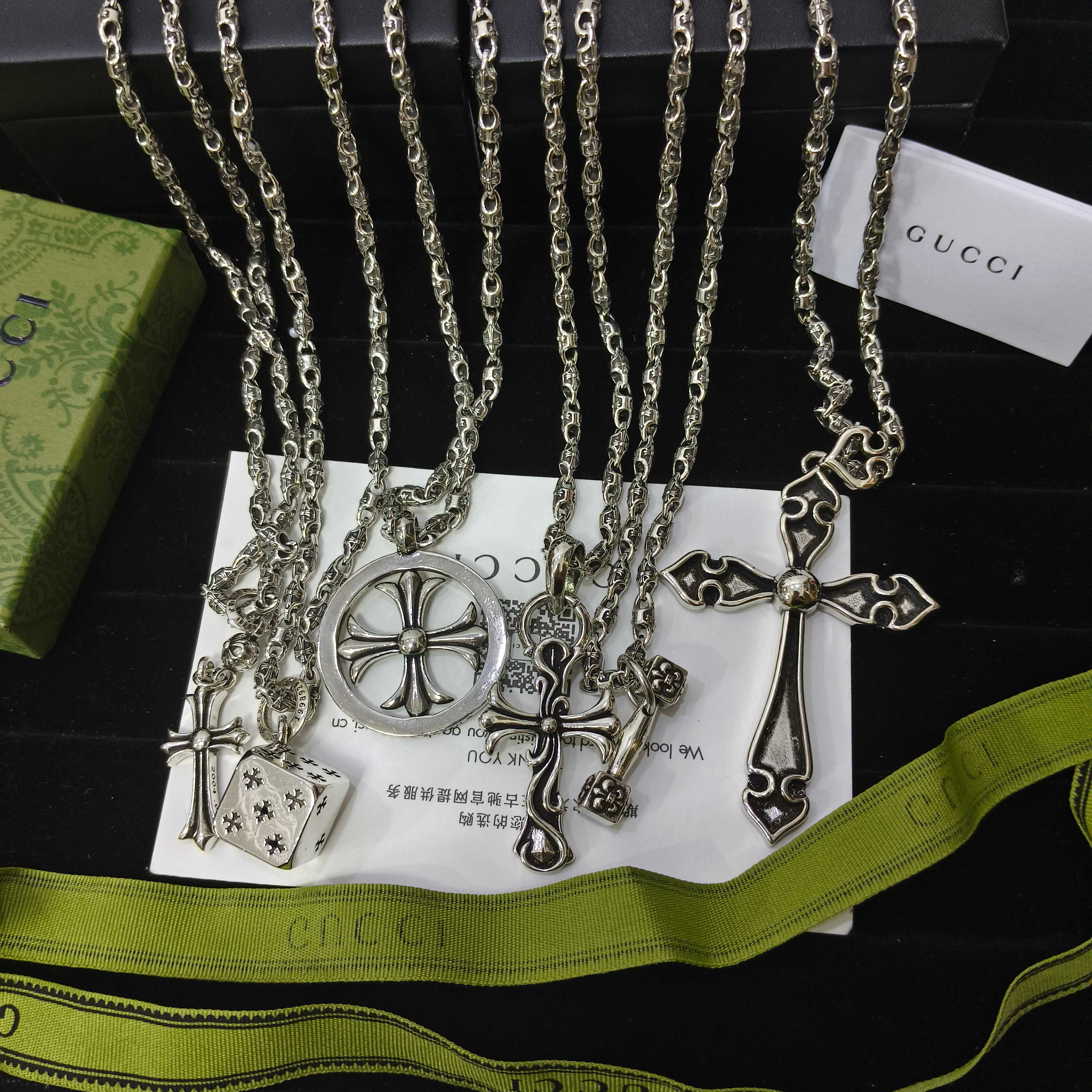 Silver-tone charm necklace set with cross, key, and lock pendants on chains