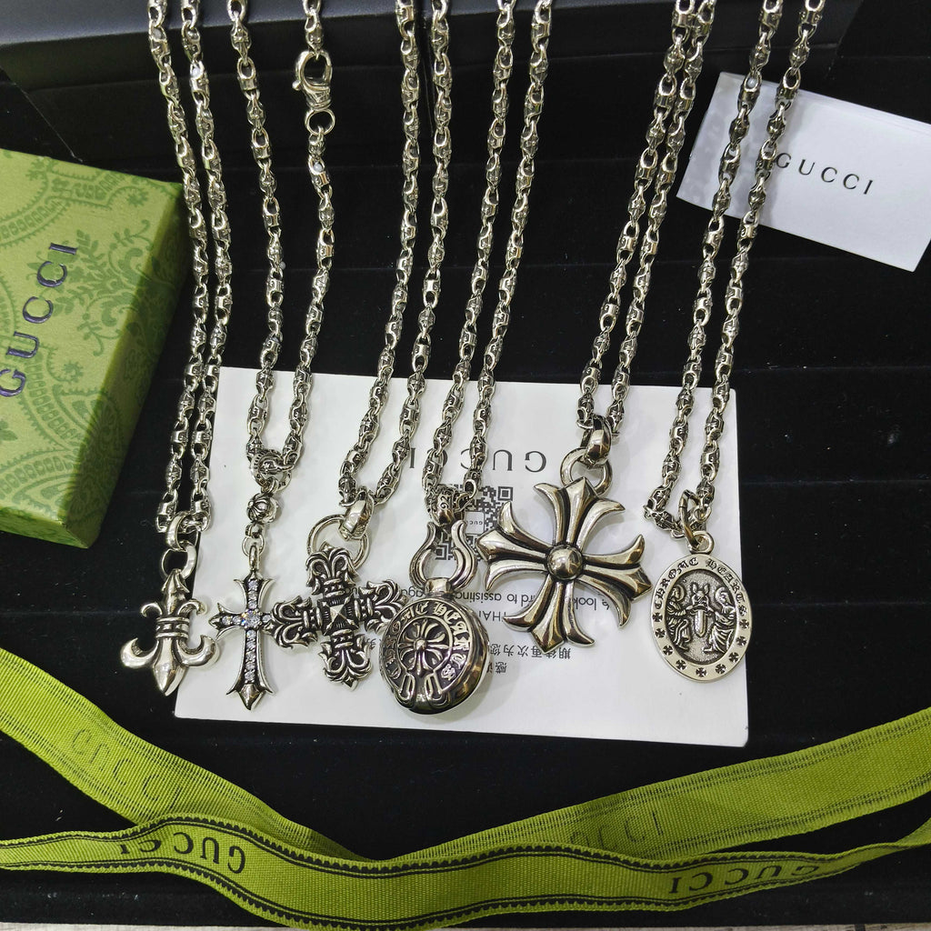Silver-tone charm necklace set with cross and circular medallion pendants on chains