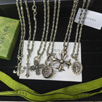 Silver-tone charm necklace set with cross and circular medallion pendants on chains