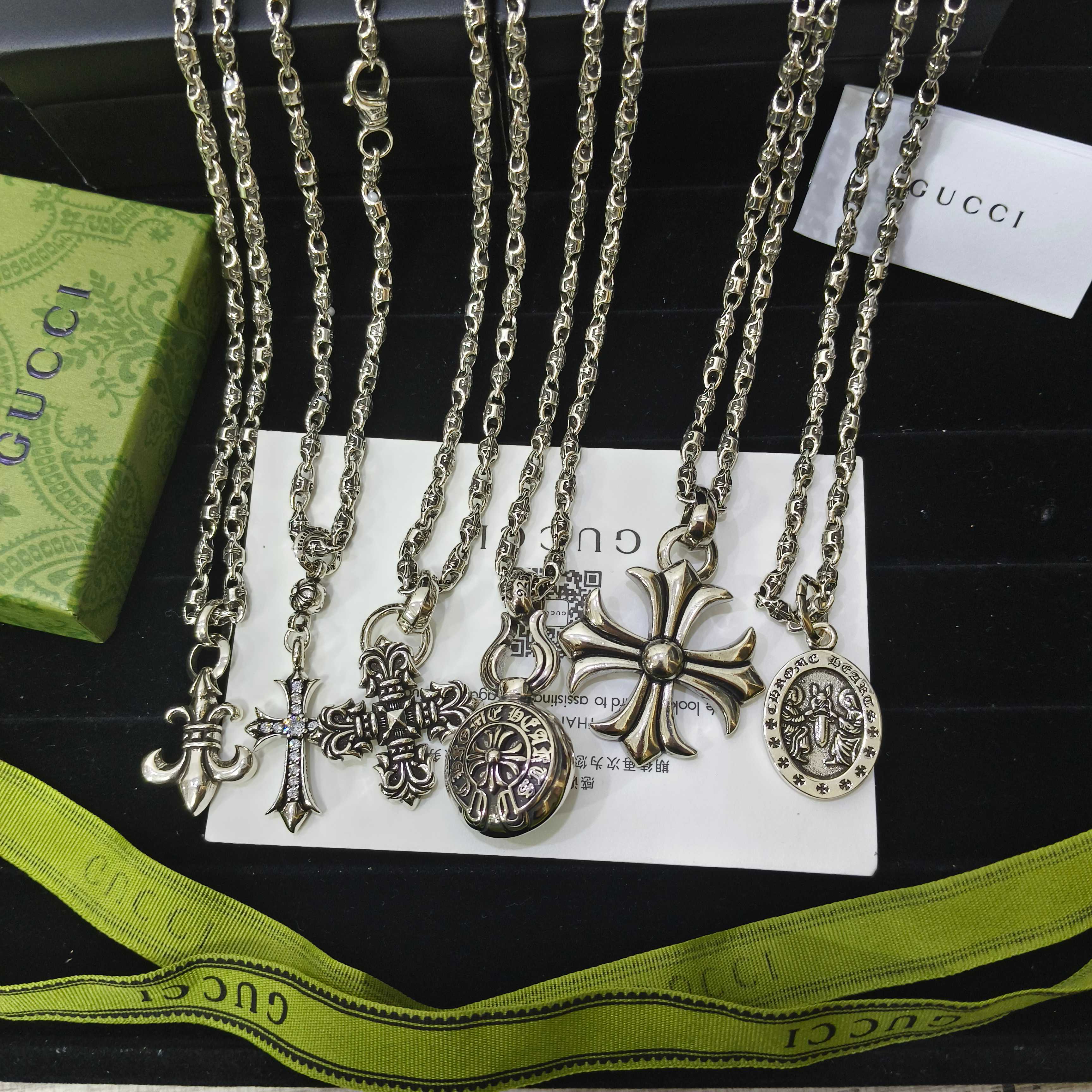 Silver-tone charm necklace set with cross and circular medallion pendants on chains