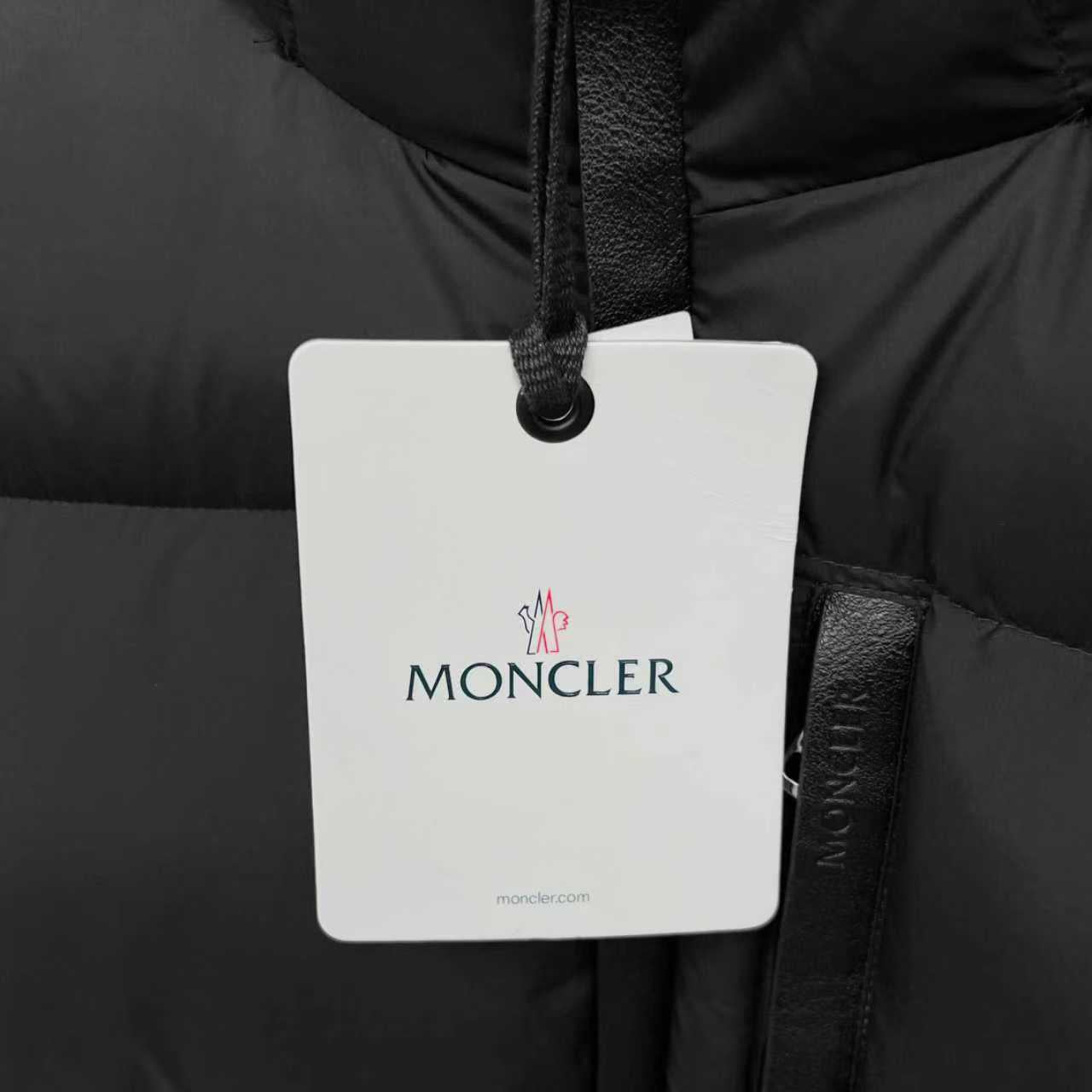 Moncler logo hang tag on black puffer jacket