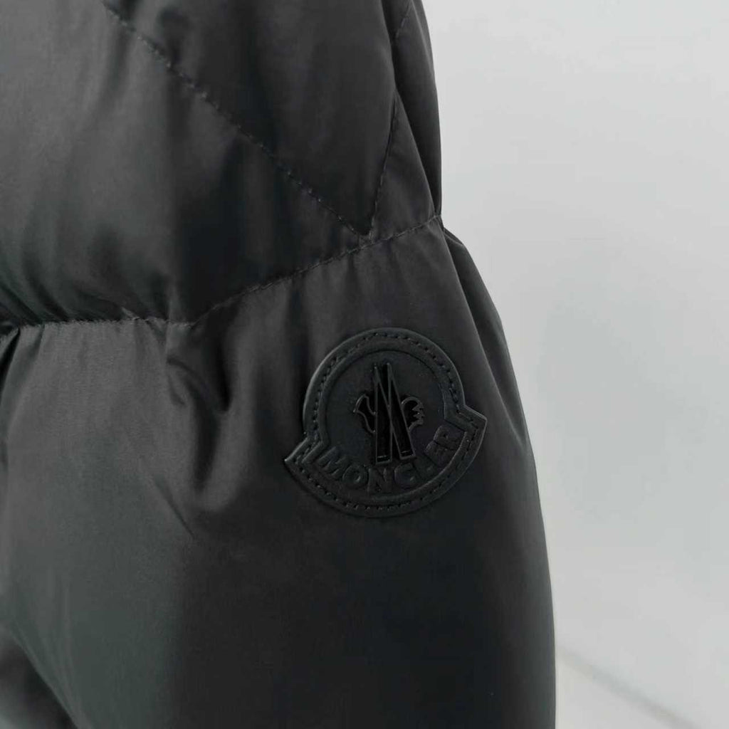 Black puffer jacket sleeve with embossed Moncler patch