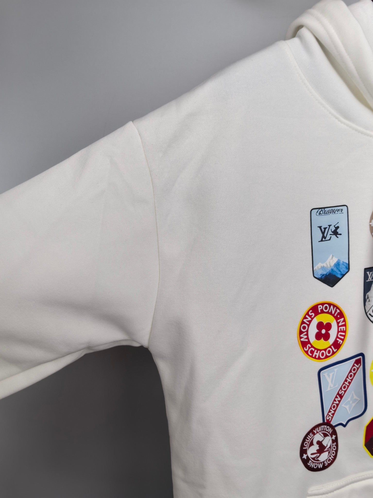 White Louis Vuitton hoodie sleeve with multicolor logo patch graphic