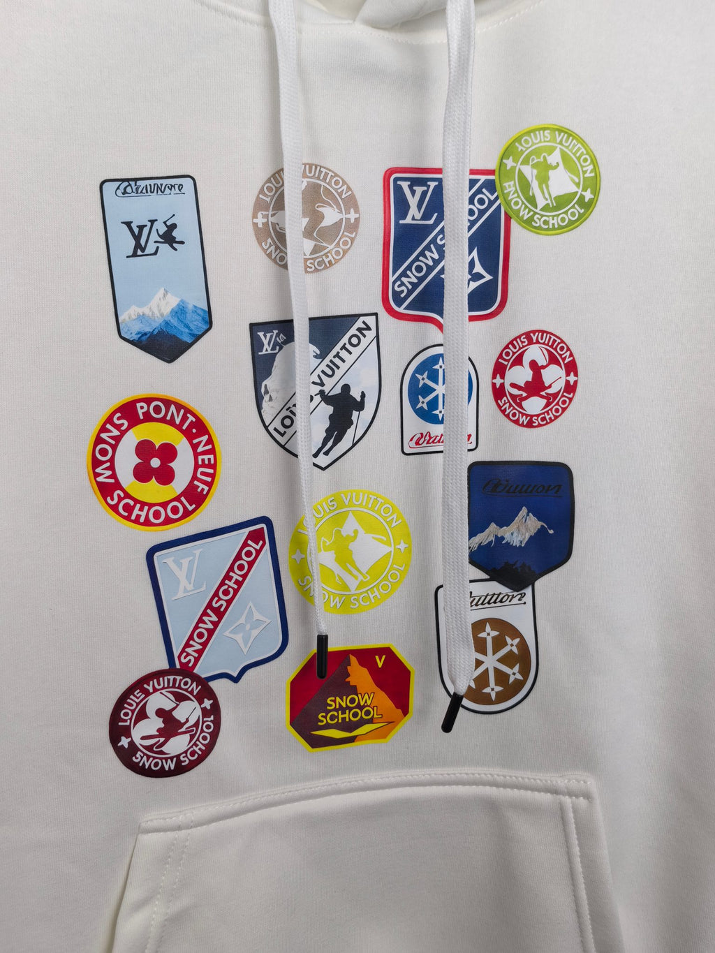 White Louis Vuitton hoodie front with multiple logo patches and hood drawstrings