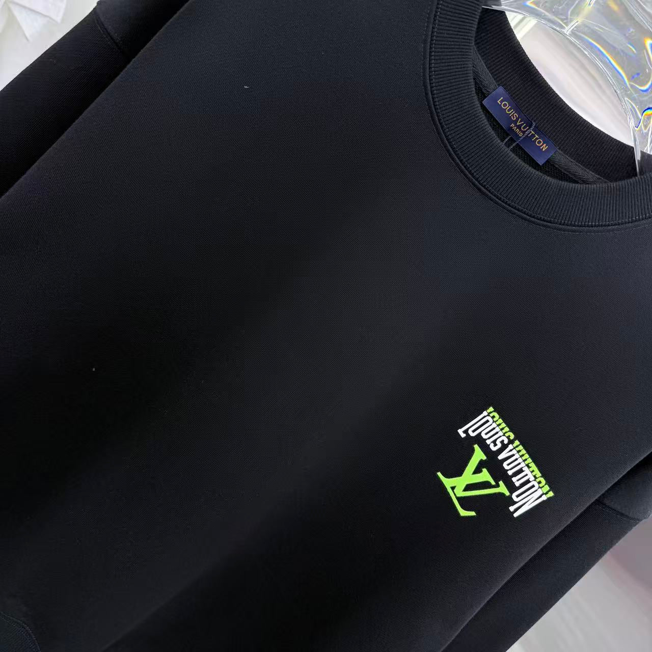 Black Louis Vuitton crewneck sweatshirt close-up of ribbed collar and logo