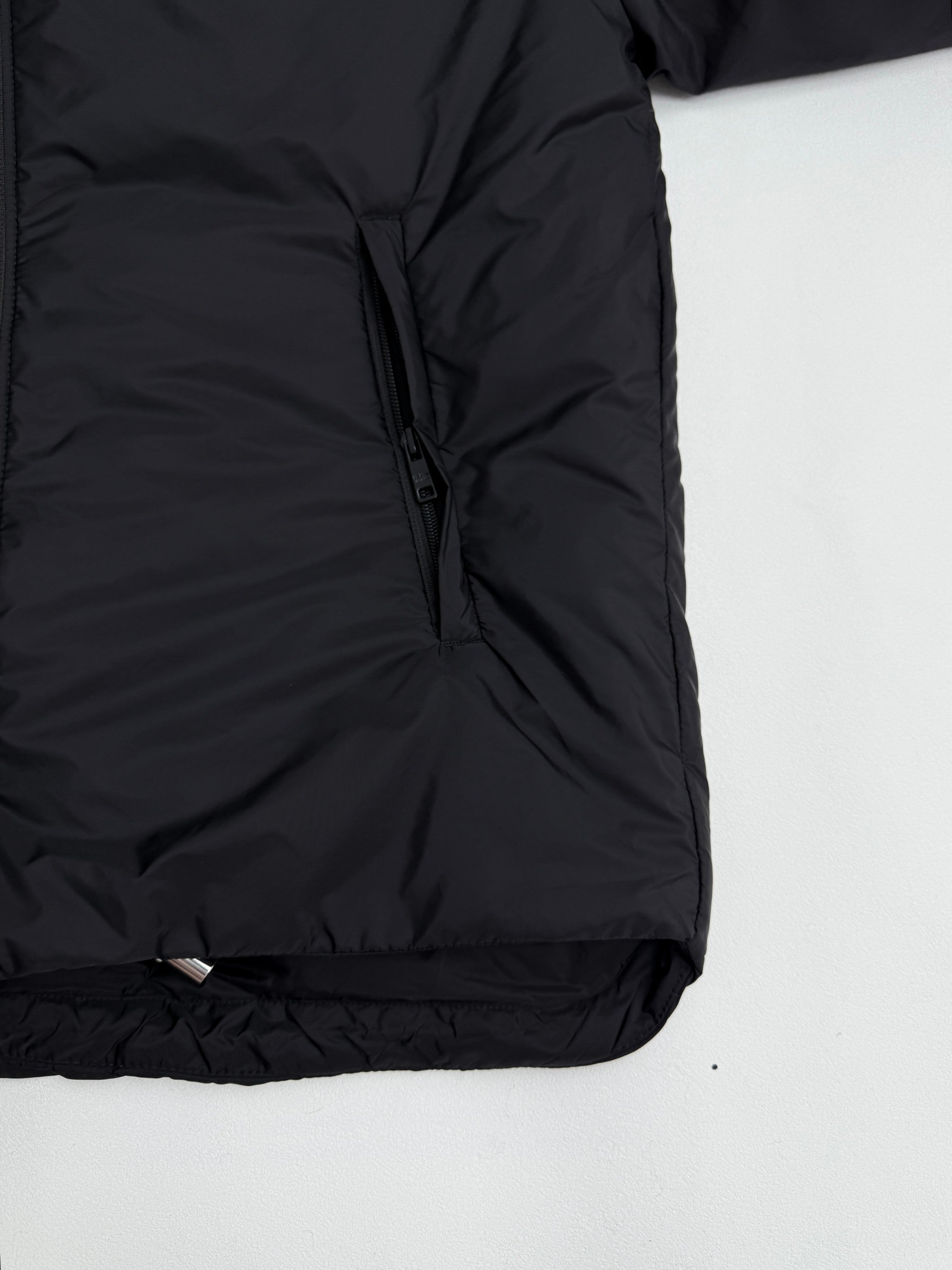 Prada hooded puffer jacket hem, dark black, side view