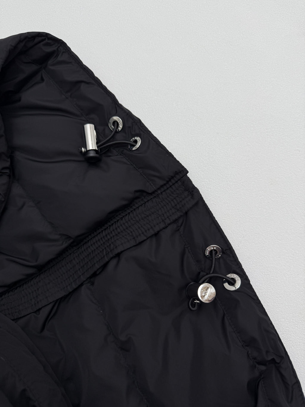 Prada hooded puffer jacket with drawstring and metal toggles, dark black