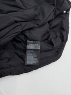 Prada interior care label on dark puffer jacket, fabric close-up