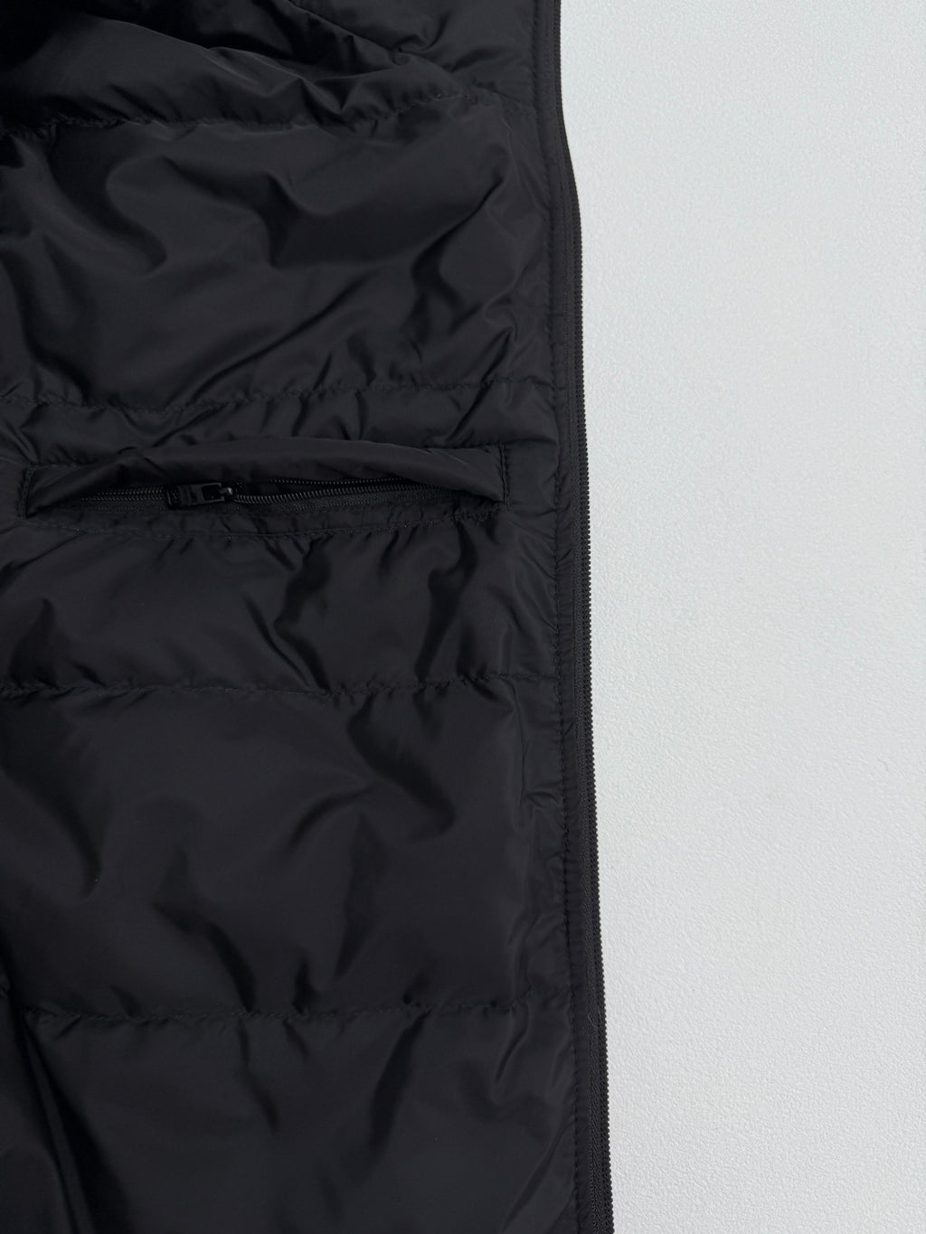 Prada puffer jacket front seam detail, dark black, close-up