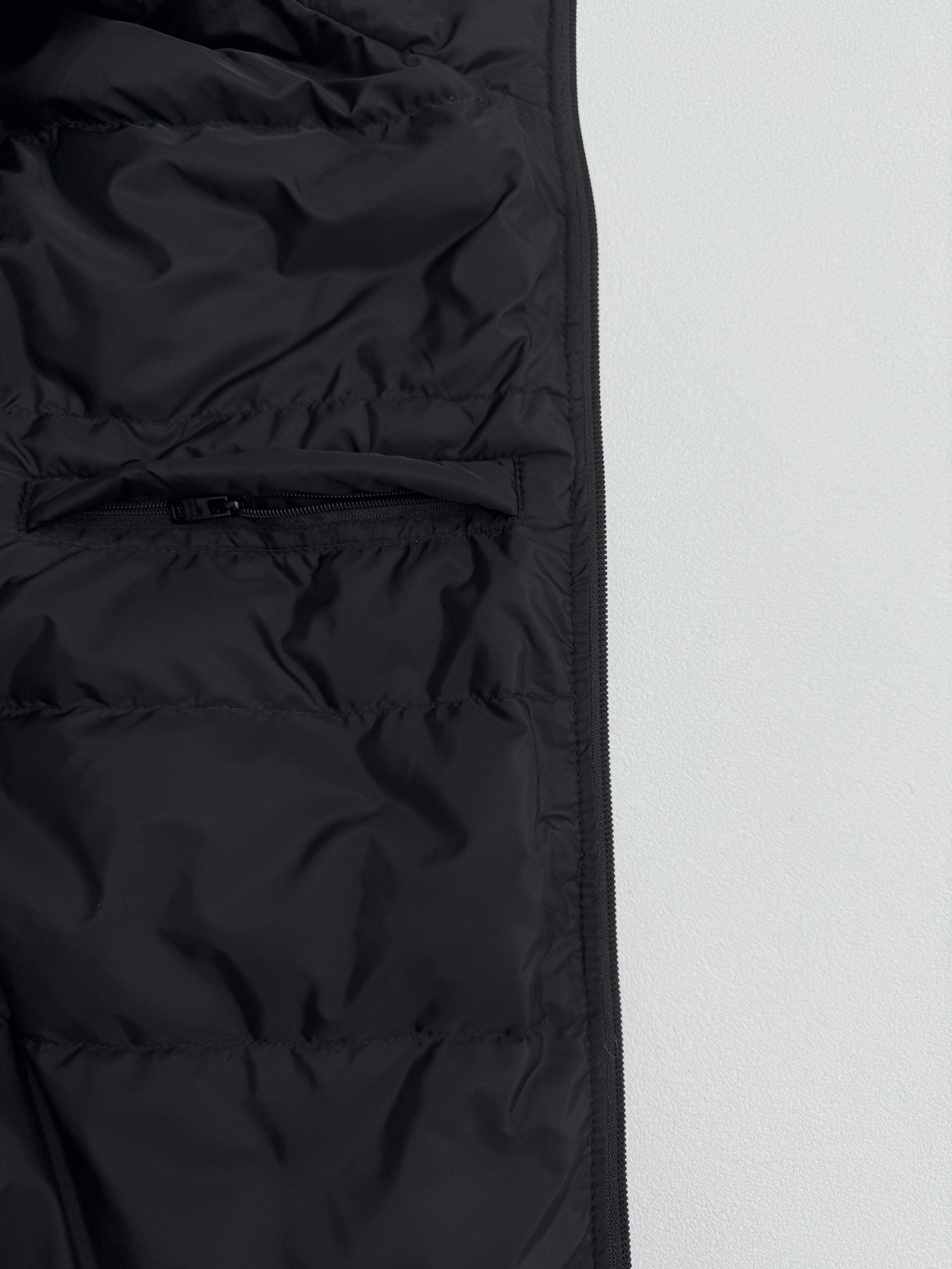 Prada puffer jacket front seam detail, dark black, close-up