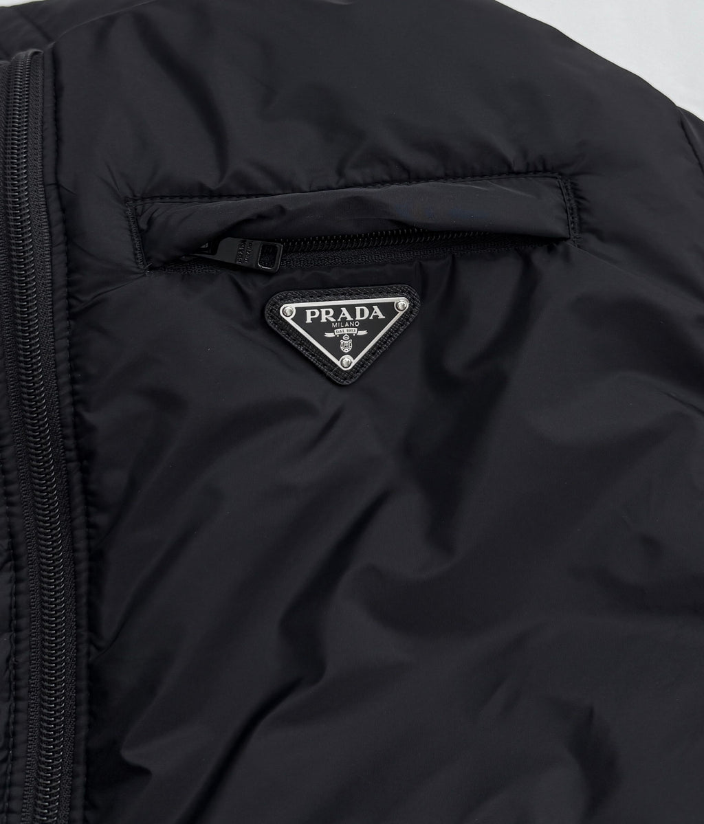 Prada triangular logo patch on dark hooded puffer jacket