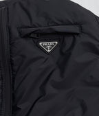 Prada triangular logo patch on dark hooded puffer jacket