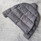 Gray Balenciaga puffer jacket laid out, back showing horizontal quilted panels.